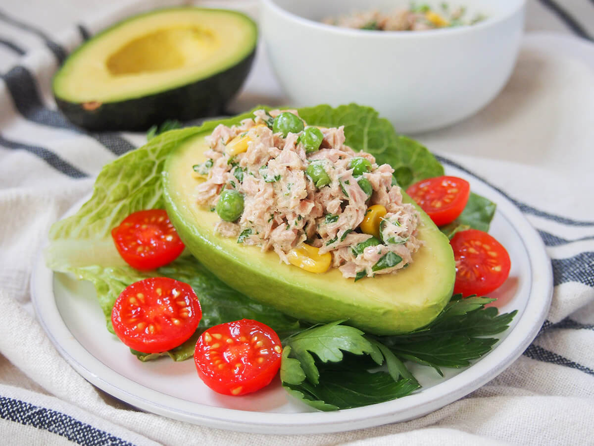 Tuna stuffed avocado (palta rellena de atun) palta rellena, tuna stuffed avocado, with tomatoes around on plate