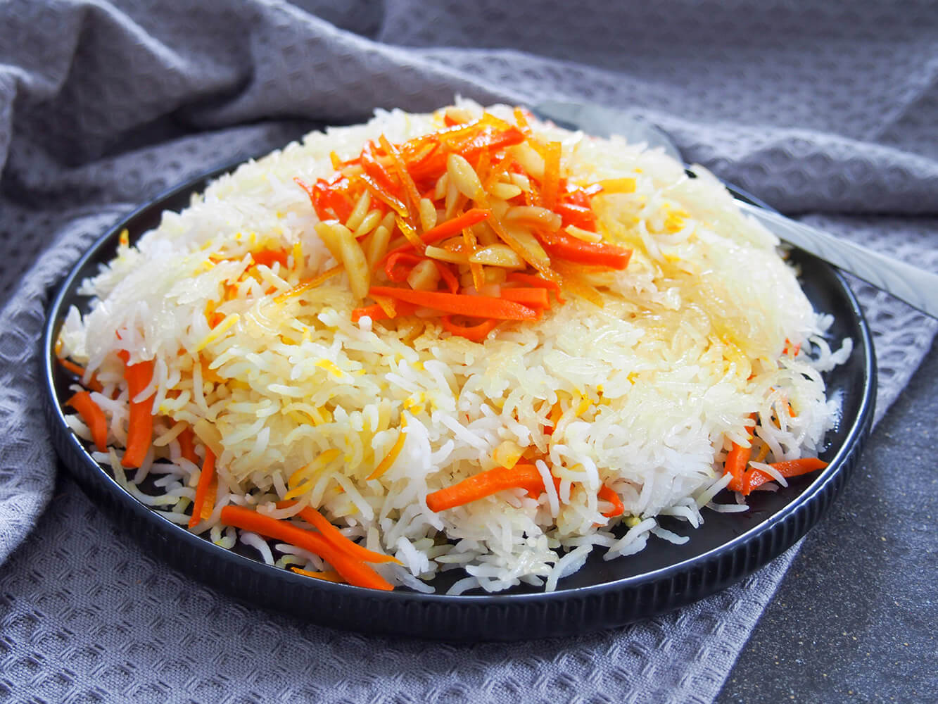 Persian sweet rice, shirin polow, is traditionally served at special occasions and it is indeed a special side. But it's one that you should definitely make an excuse to enjoy more often, it's so bright and delicious! Persian sweet rice (shirin polow) with carrot orange topping