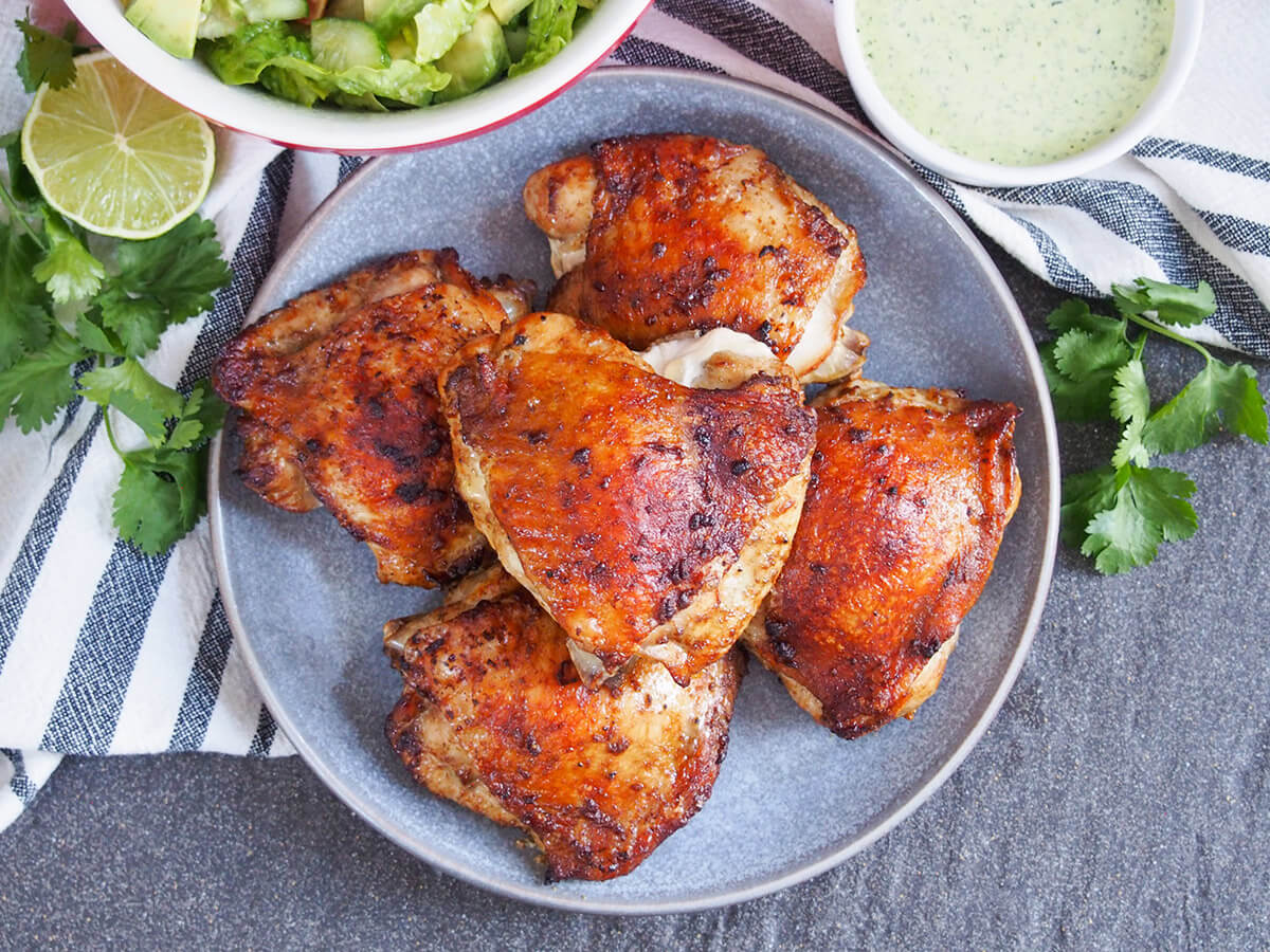 Peruvian roast chicken is traditionally made with whole chickens on a spit, but you can recreate the deliciousness with your oven. A simple but flavorful marinade adds an extra layer of flavor. plate of Peruvian roast chicken, pollo a la brasa, from overhead