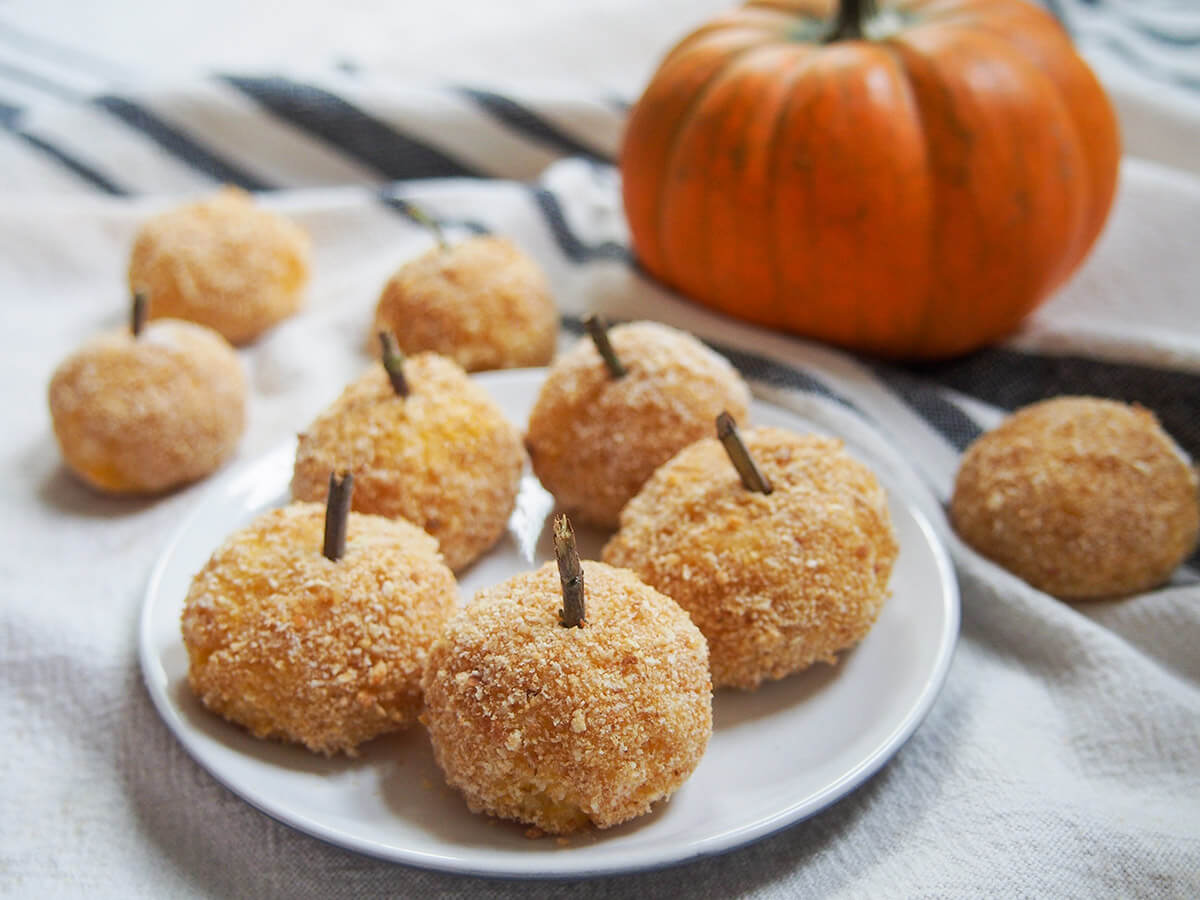pumpkin arancini on plate plate of pumpkin arancini with mini pumpkin behind