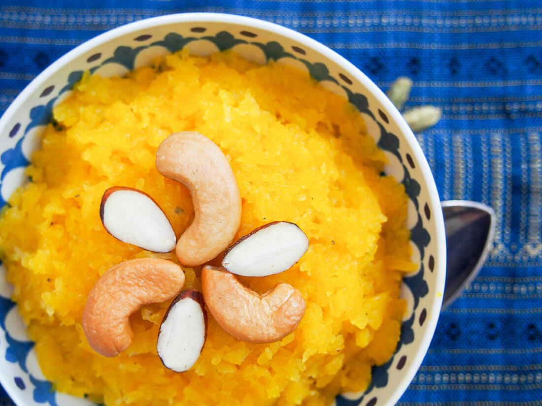 Pumpkin halwa is an Indian dessert that's easy to make, sweet and aromatic from cardamon and so comforting, you'll be hugging the bowl as you enjoy. bowl of pumpkin halwa with nuts on top