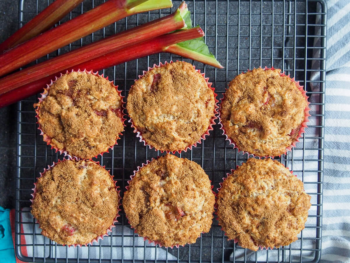 These rhubarb muffins are a delicious combination of tart bursts of rhubarb in a soft muffin and warm sweet cinnamon sugar topping. They make a great coffee time snack, or really any time. rhubarb muffins on cooling rack with rhubarb above