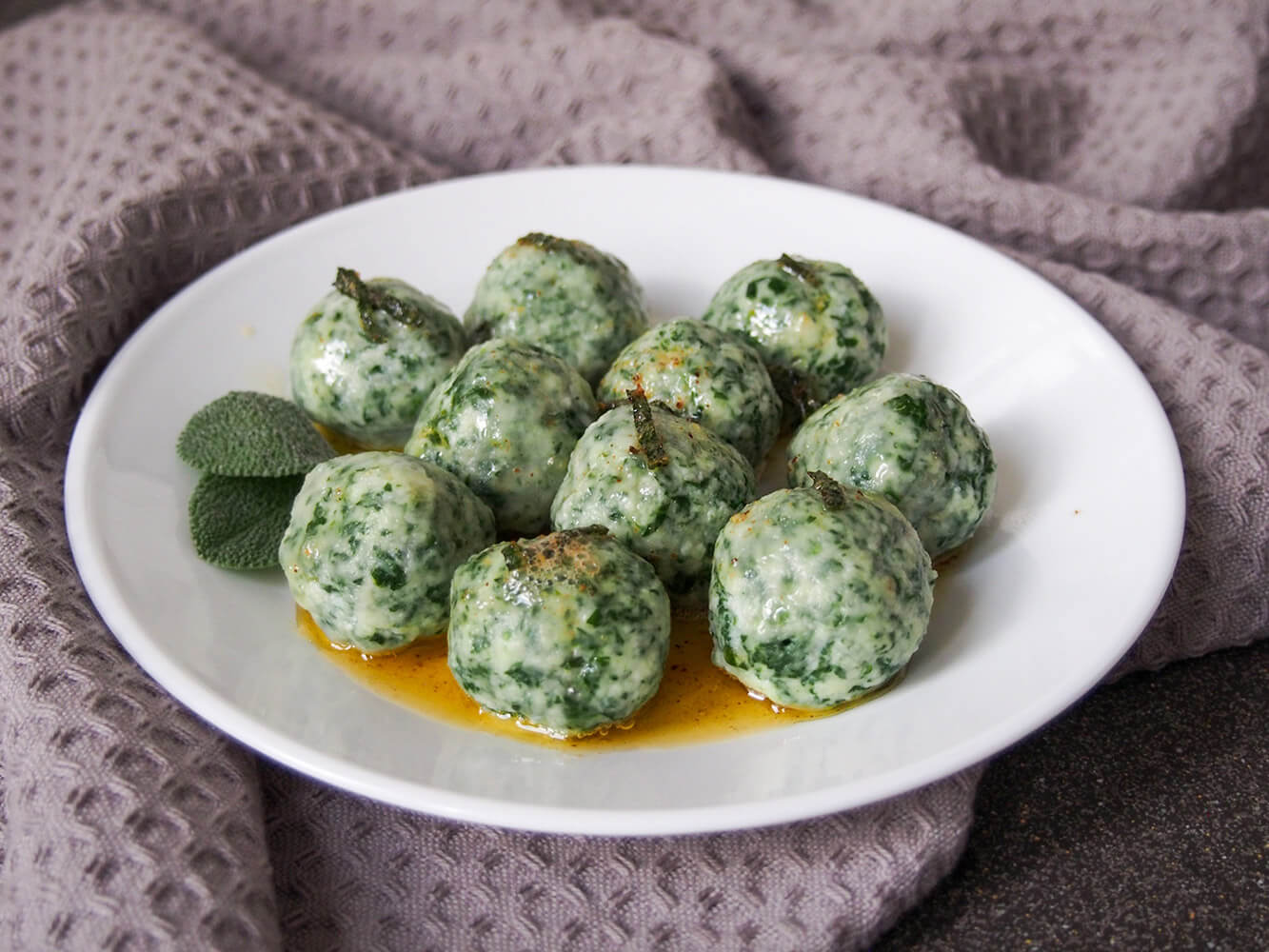 Ricotta and spinach gnudi are a little like gnocchi without the potato. They're light, cheesy and incredibly comforting and delicious! Ricotta and spinach gnudi on plate with sage browned butter