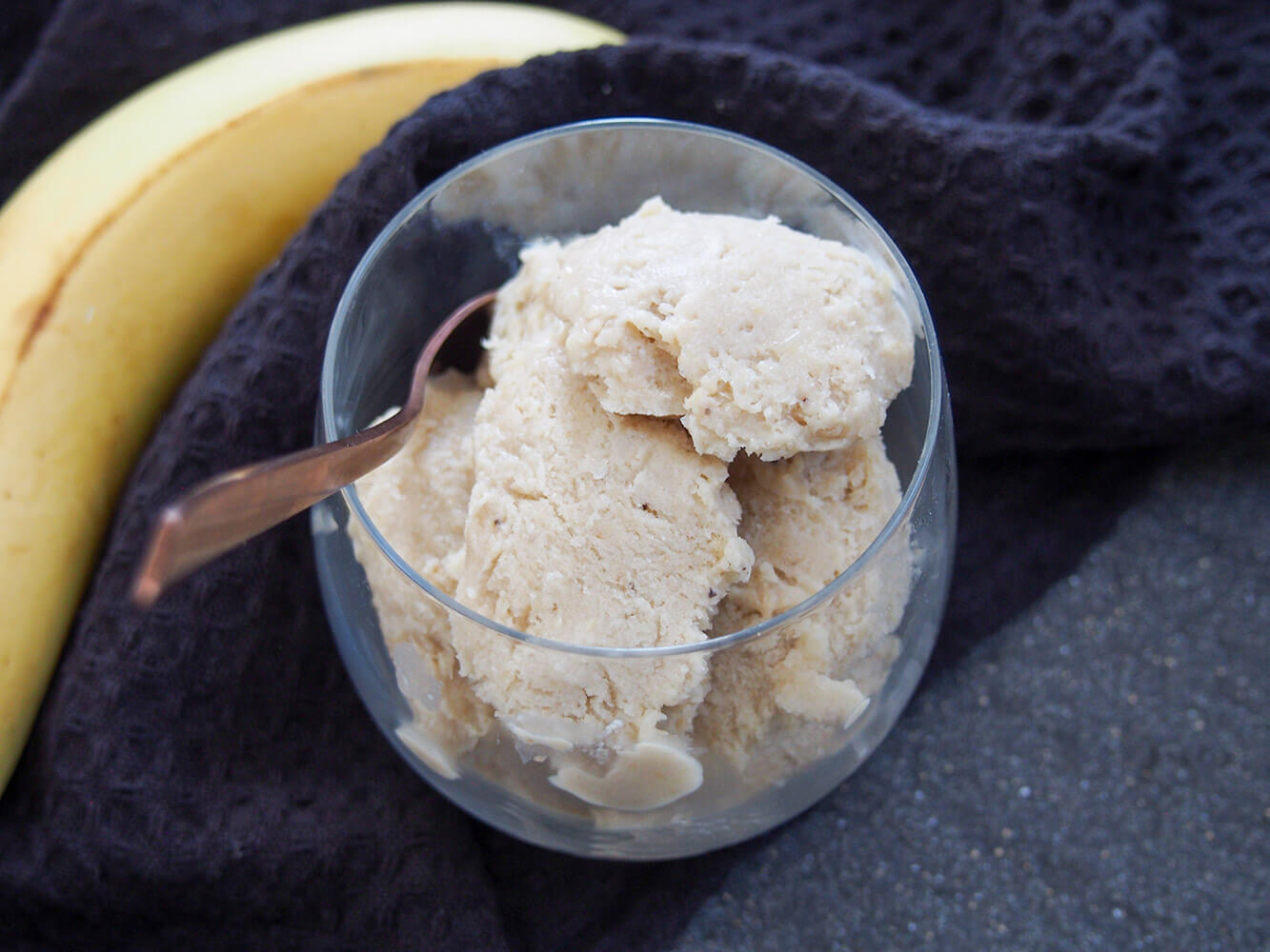 This roasted banana ice cream is perfect for overripe bananas - it has lots of wonderful banana and caramel-like flavor and come together easily too. Roasted banana ice cream in glass with spoon in side of glass