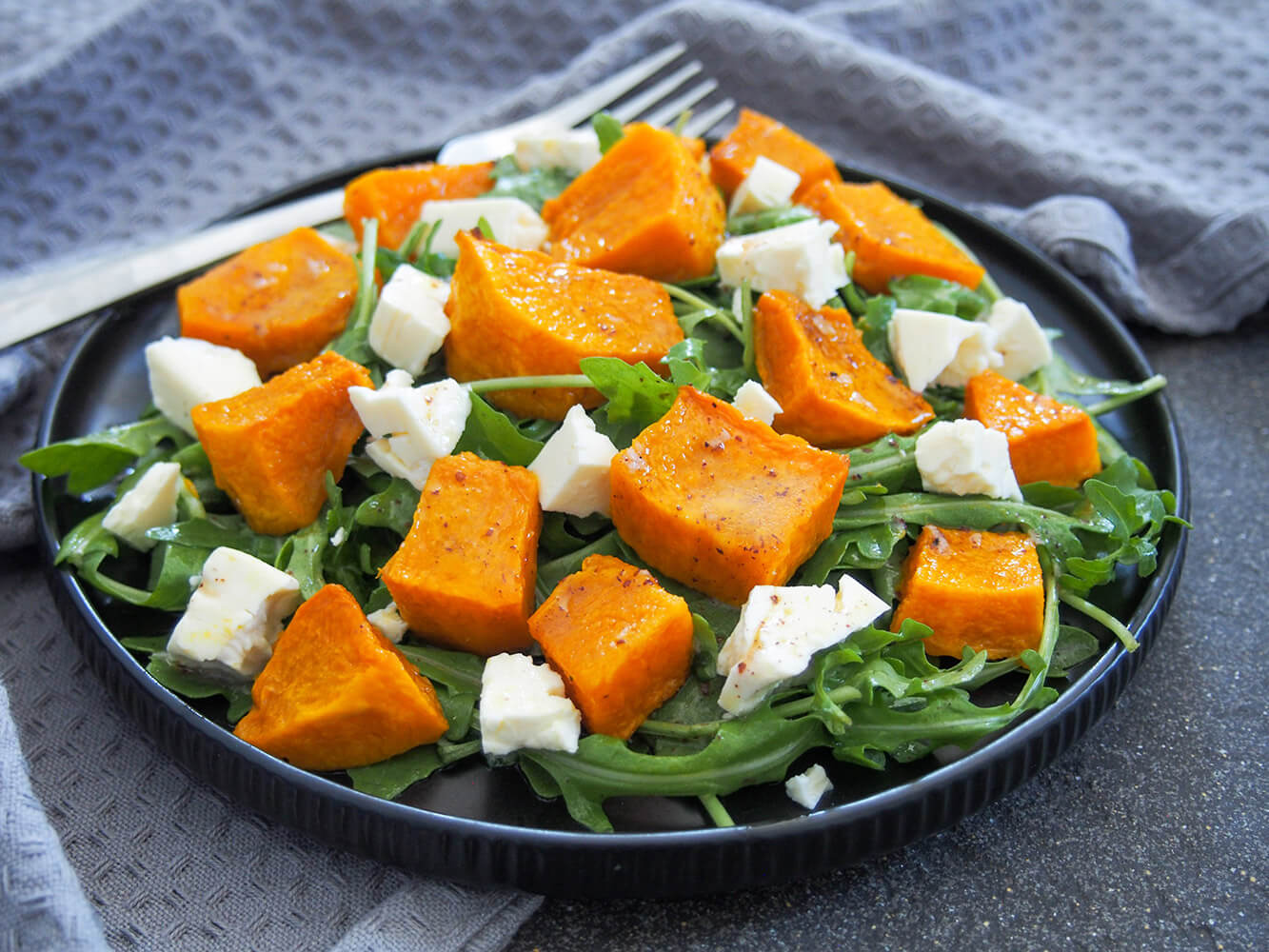 This roasted kabocha squash salad with feta is really easy to make and easily adapted. It has a tasty mix of comforting squash and a tangy dressing that works for lunch, as an appetizer or side. plate of roasted kabocha squash salad with feta