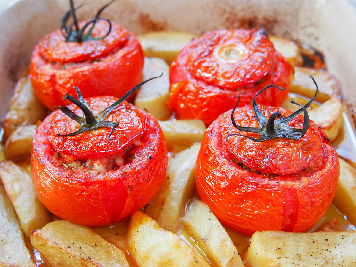 tomatoes stuffed with rice in dish four tomatoes stuffed with rice in dish with potatoes around