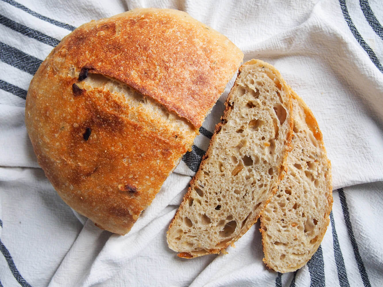 sage and caramelized onion sourdough bread - a delicious balance of slightly tangy, with sweet bursts of onion and a wonderful texture sage and caramelized onion sourdough bread from overhead with two slices to side