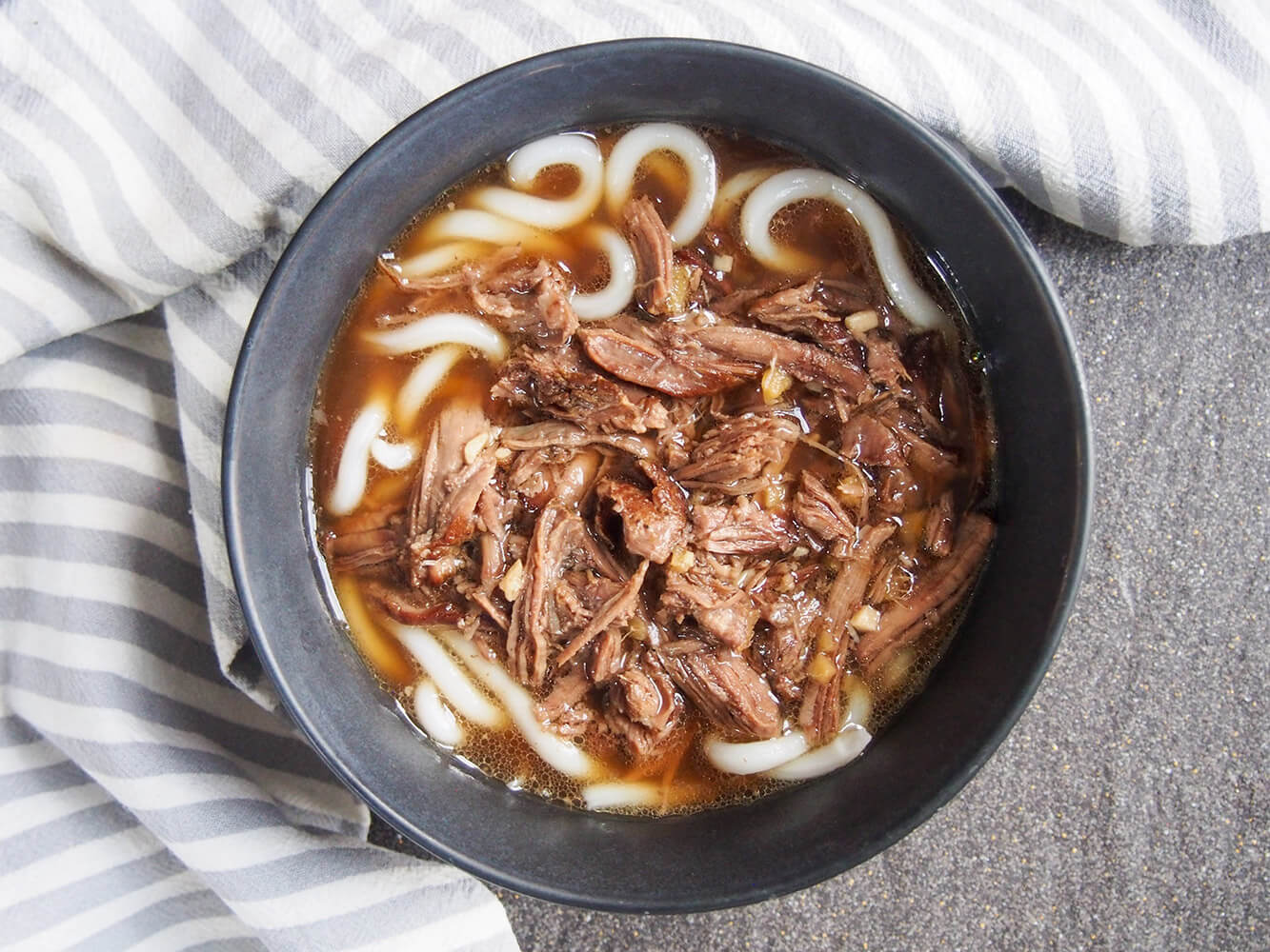 This short rib beef udon uses a variation on a classic Japanese dashi-based broth to slow braise the beef, giving an incredibly flavorful base for this beef noodle dish. short rib beef udon overhead shot