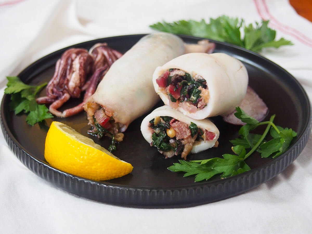 Sicilian style stuffed squid is an easy and delicious way to prepare this seafood quite differently from your typical fried rings plate of Sicilian style stuffed squid with lemon slice and parsley garnishes