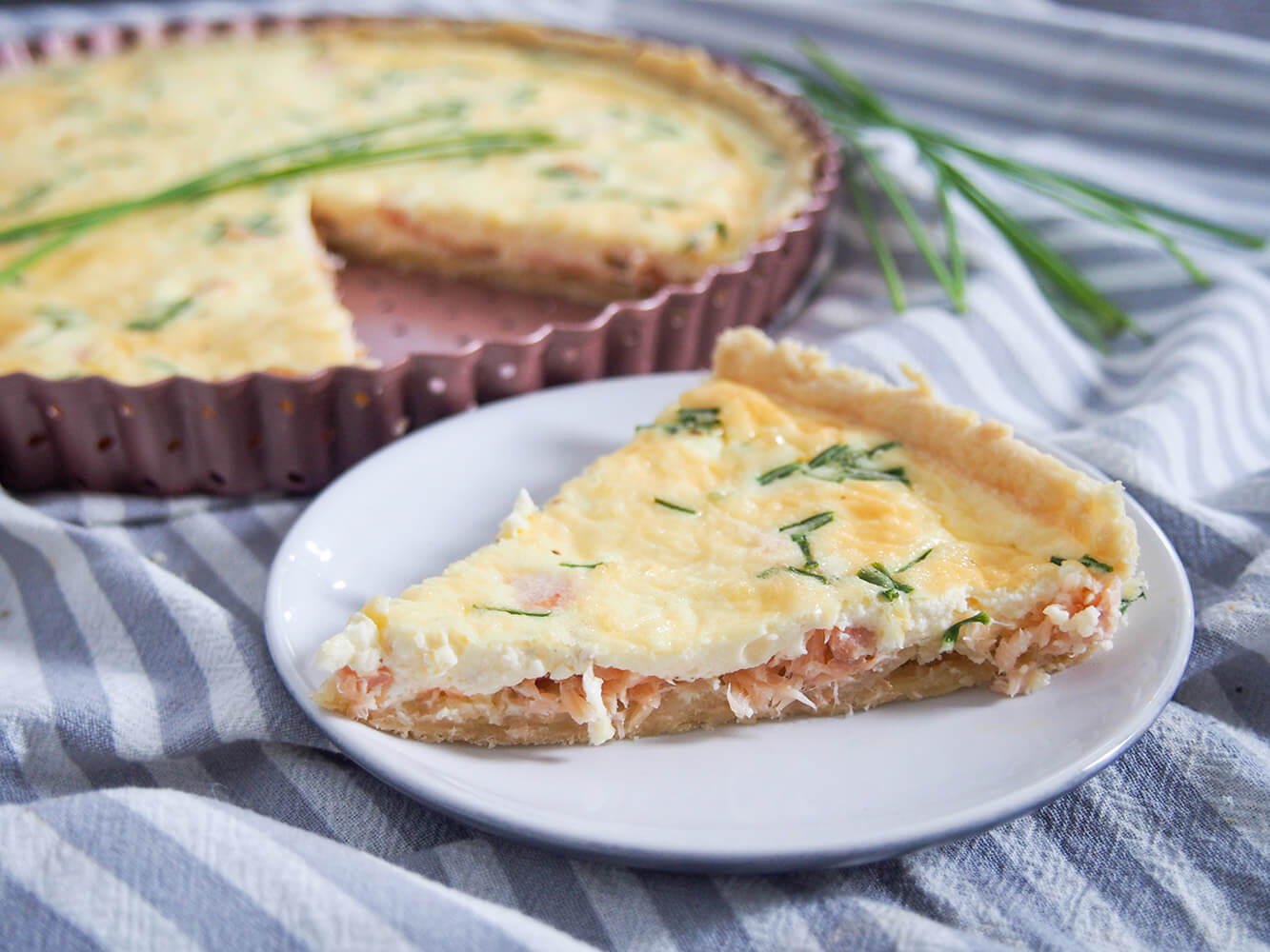 This smoked salmon quiche is easy to make, with a delicious flavor and makes a wonderful brunch or lunch option. smoked salmon quiche with slice on plate in front