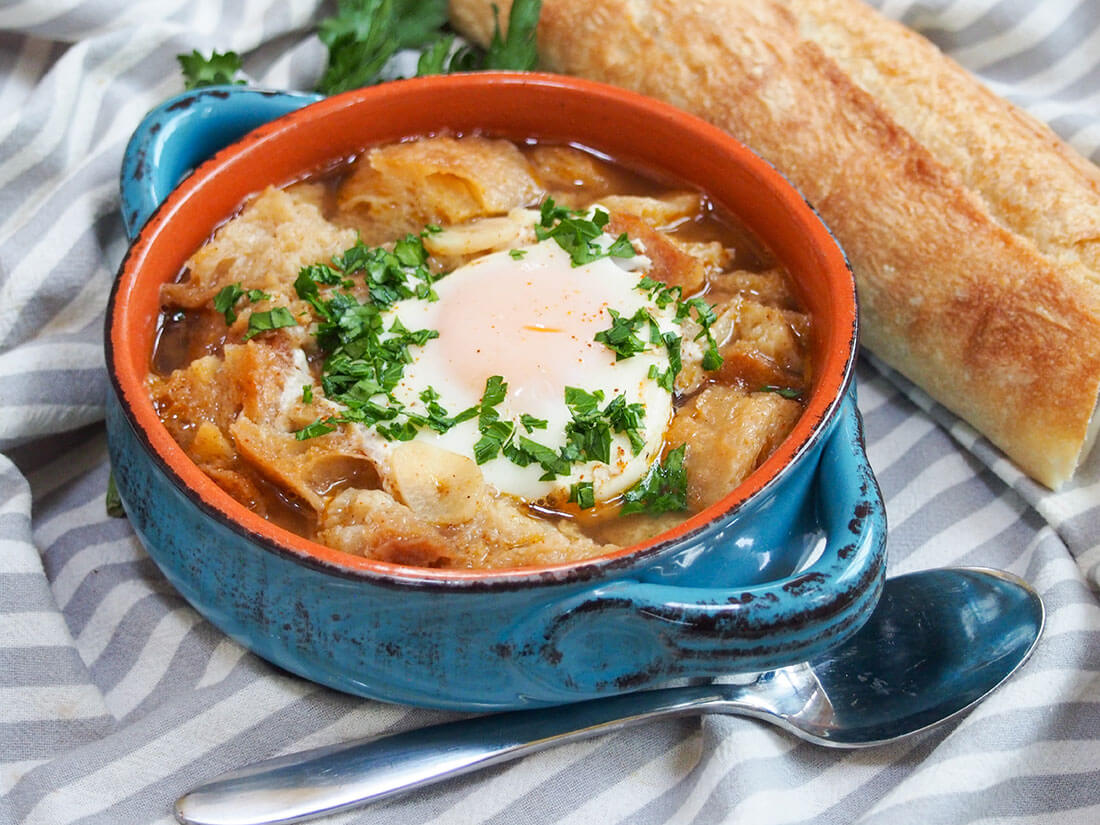 This garlic soup may not have many ingredients, but Spanish sopa de ajo is packed with more flavor than you might think. It's easy to make, rustic and comforting. Just what you need on a cold day. bowl of sopa de ajo with spoon in front