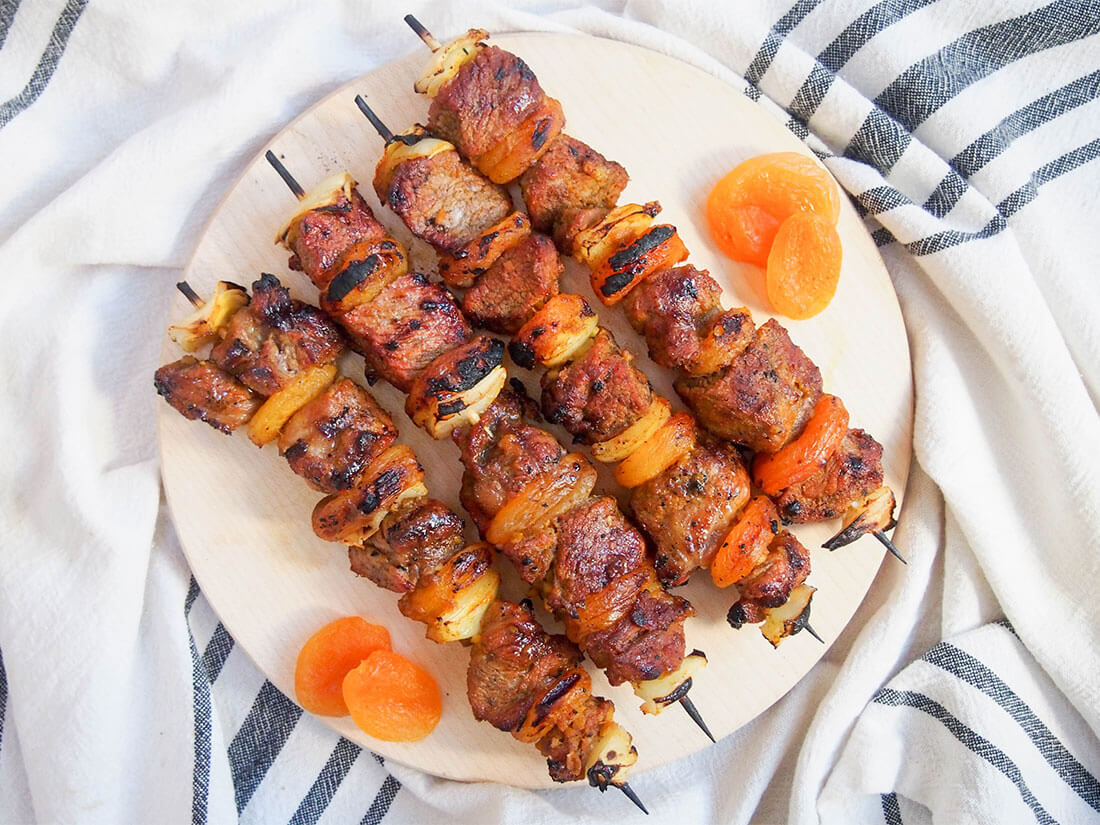 Lamb sosaties are a common feature of a classic South African braai (BBQ). The apricot and curry marinade might sound unusual but it adds a wonderful flavor to these tasty kebabs. So easy and delicious! Sosaties (South African lamb and apricot kebabs) on board with apricots to either side