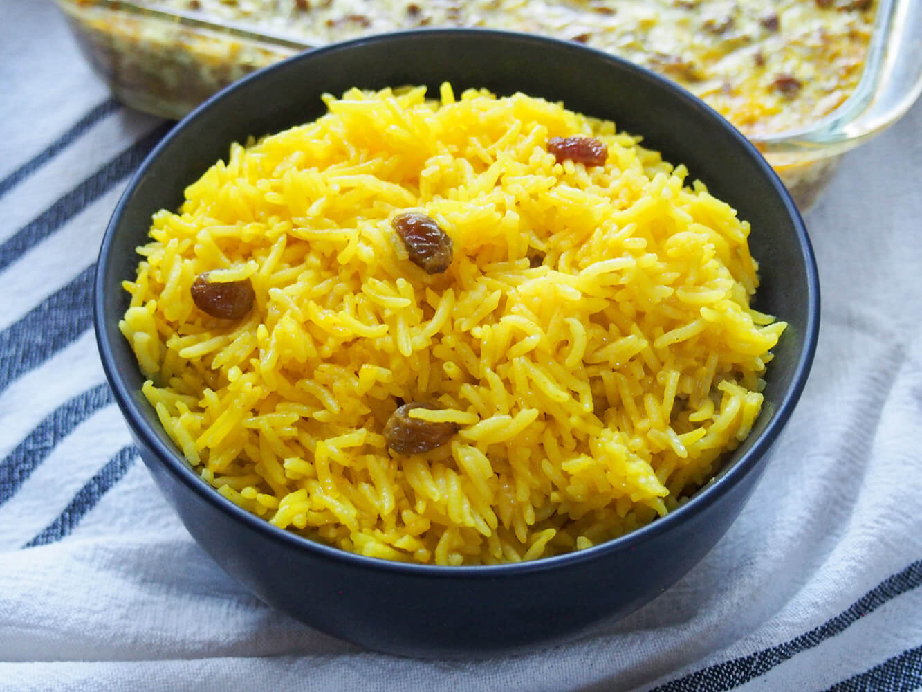 South African yellow rice is an easy and colorful way to brighten up plain rice. It's a classic side to bobotie, but works with many other dishes as well. bowl of South African yellow rice
