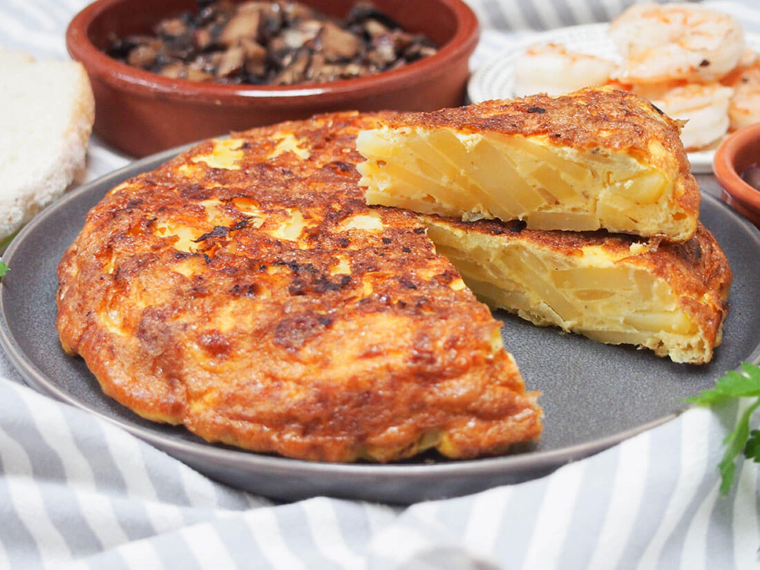 Spanish tortilla, tortilla Española is a classic Spanish tapas that's also great for a picnic Spanish tortilla (tortilla Española) with a slice cut out and on top