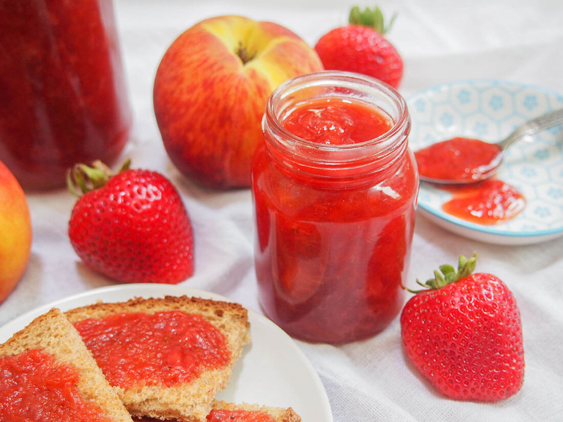 This strawberry peach jam is a true taste of summer. Easy to make, with less sugar than your typical jam, it's perfect on toast and so much more. strawberry peach jam in jar and on toast to side