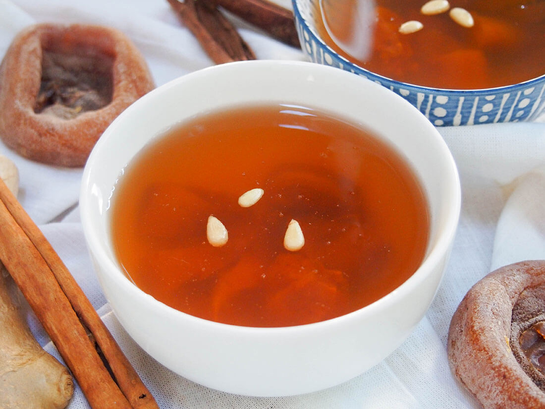 Sujeonggwa is a Korean cinnamon tea served cold, but with plenty of gently sweet warming spice flavor Sujeonggwa (Korean cinnamon tea) in bowl