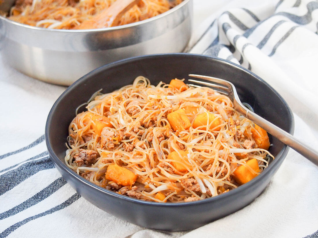 These Taiwanese pumpkin rice noodles are a fast and flavorful one pan meal. With a tasty combination of ingredients, it's a meal perfect for any night of the week. bowl of Taiwanese pumpkin rice noodles with fork in bowl