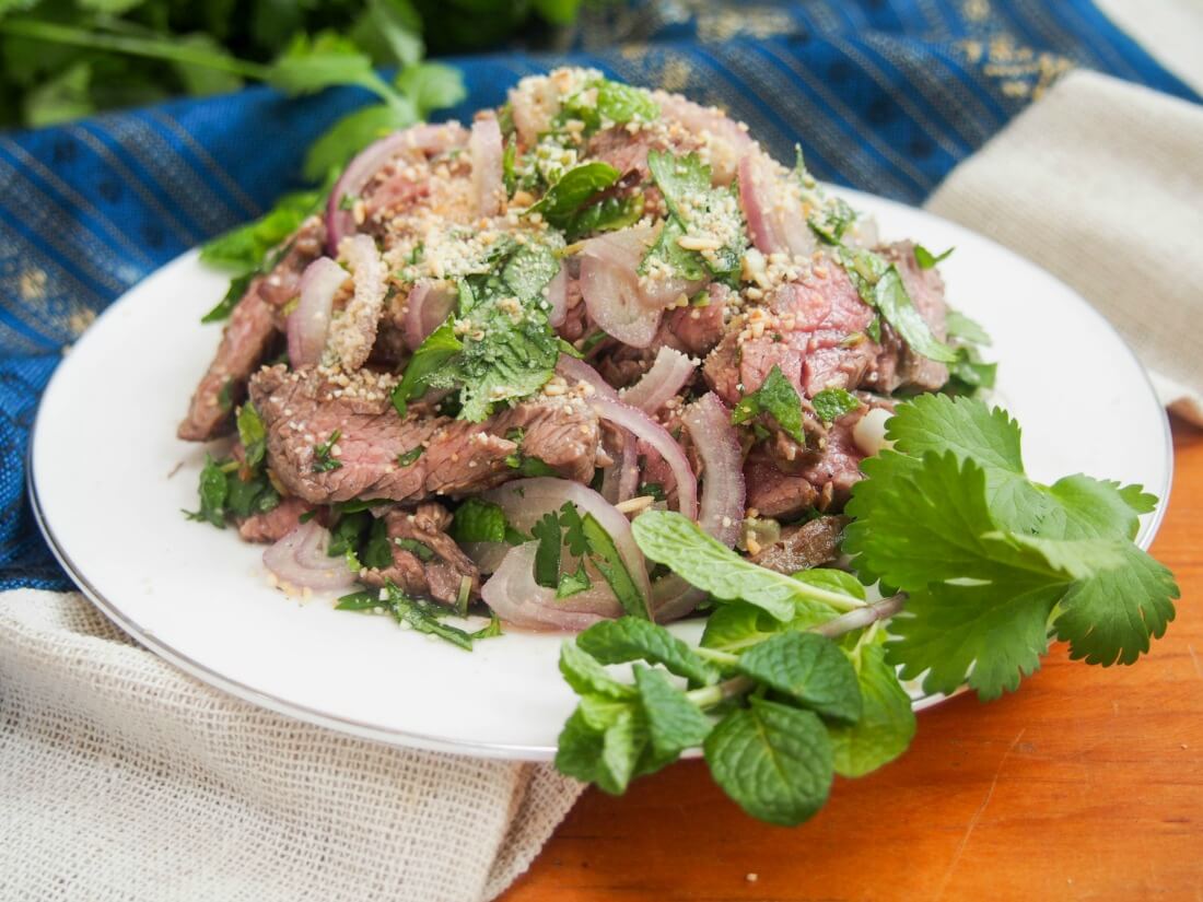 Thai beef salad (Nam Tok, 'waterfall beef') Thai beef salad (Nam Tok, 'waterfall beef') on plate decorated with herbs