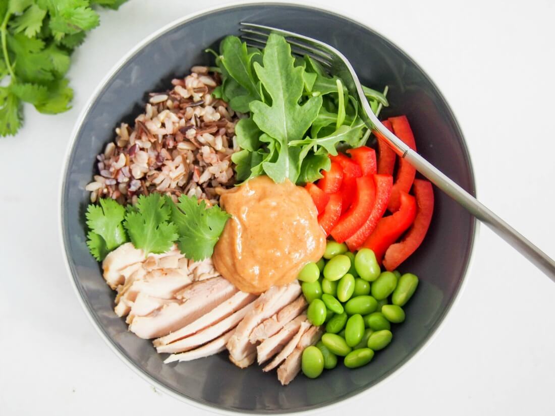 If you're ever on the hunt for healthy, easy leftover chicken recipes, this Thai-style leftover chicken Buddha bowl needs to be on your list. It's really quick and easy to make, packed with goodness and delicious too. Thai-style leftover chicken Buddha bowl with fork in top of bowl from overhead