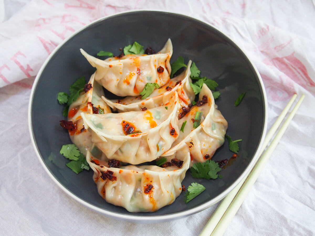 These vegetable dumplings are filled with a tasty and colorful mix of veggies. They have a great texture too and are perfect with a simple dipping sauce or, my favorite, chili oil. So good, you definitely won't miss the meat! bowl of vegetable dumplings (jiaozi) with chopsticks to side