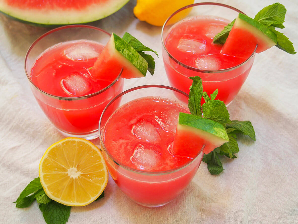 Watermelon lemonade is a delicious and pretty twist on a classic homemade lemonade. Easy to make, refreshing and tasty, you'll be drinking it all summer long. three glasses of watermelon lemonade (or watermelon mint lemonade) with half lemon to side