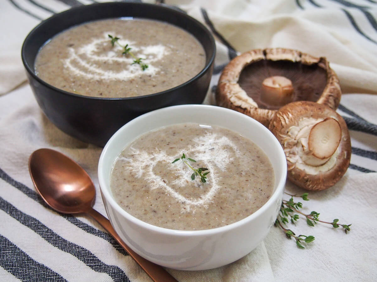 This wild mushroom soup uses a blend of mushrooms to add more depth of flavor, but with all that wonderful earthiness and smooth creaminess you would expect. It's easy to make, comforting and delicious. white bowl with wild mushroom soup and black bowl of soup behind